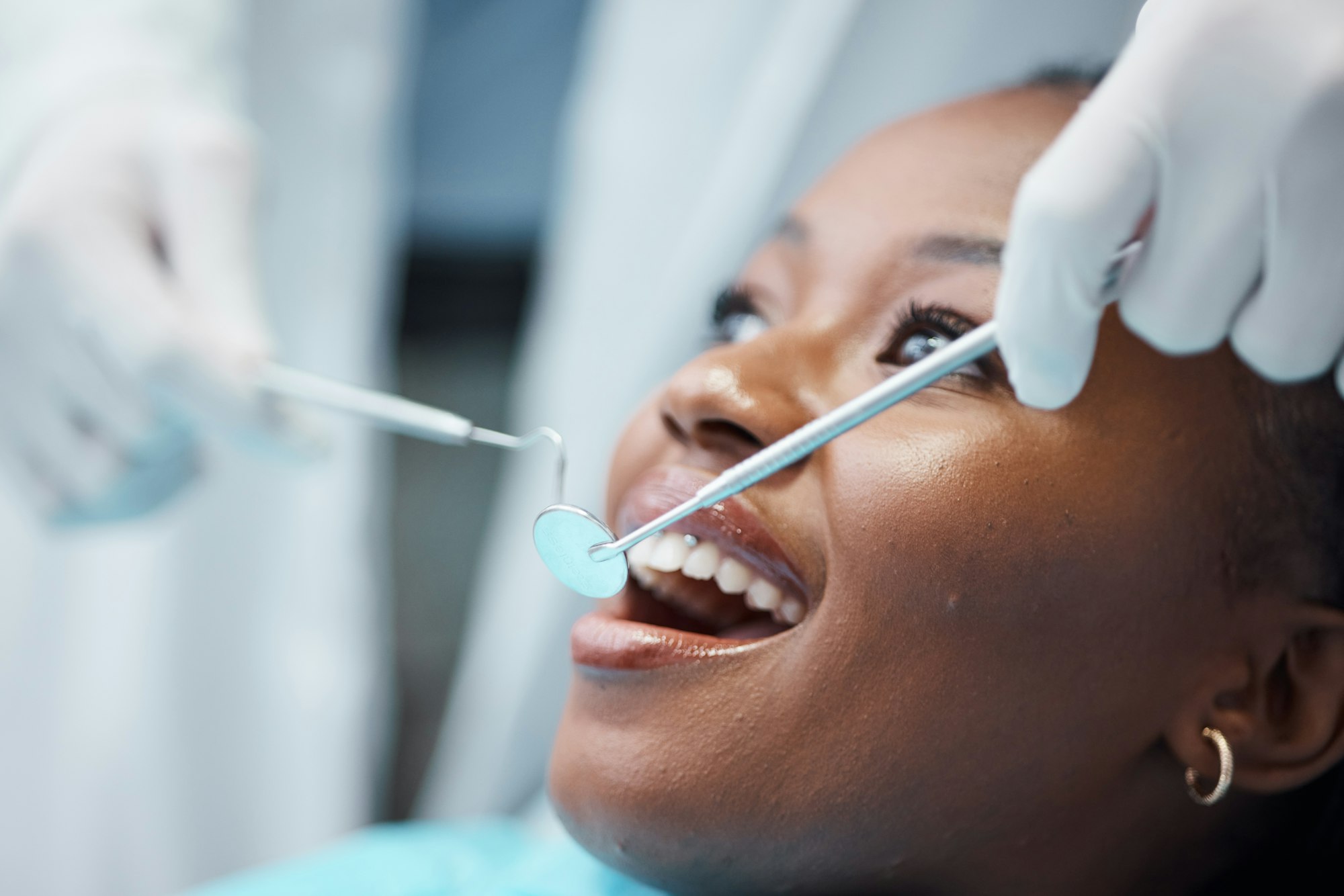 Black woman, mouth and face with dentist, tools in hands and dental, teeth check for healthcare wit